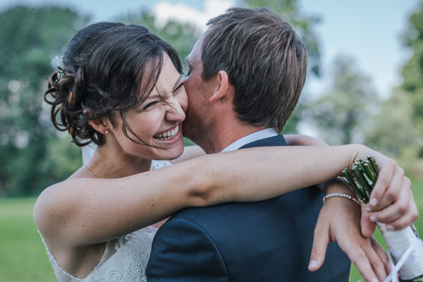 Hochzeit in Deggendorf, Paarshooting, Braut umarmt den bräutigam und lacht dabei