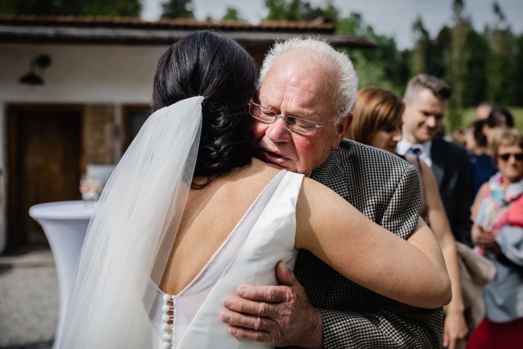 Hochzeit auf Gut Aichet, die Braut umarmt ihren Opa