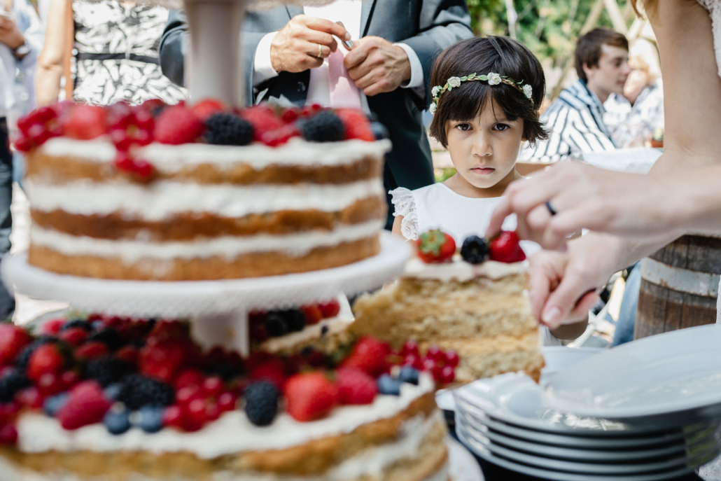 Hochzeitsreportage in Passau, standesamtliche Trauung und Feier im Biowirtshaus "Zum Fliegerbauer", Kind schaut auf Torte