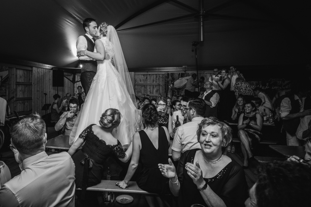 Hochzeit in Ruckasing, das Brautpaar steht auf dem Tisch und küsst sich vor allen Gästen