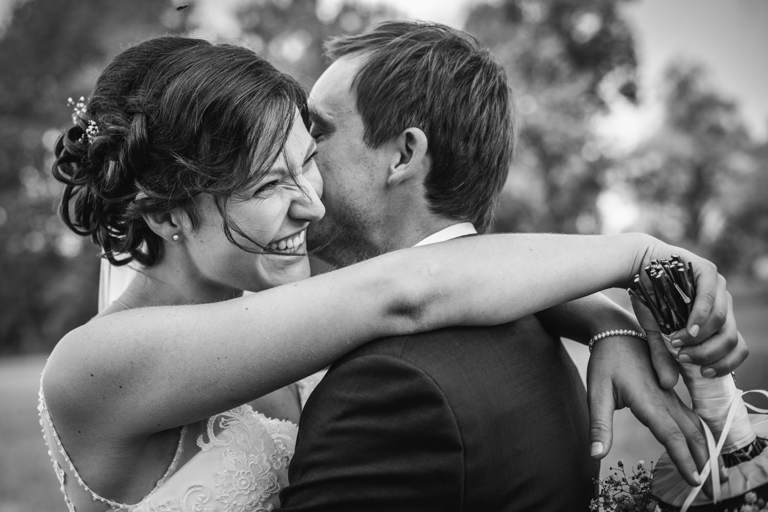 kirchliche Hochzeit in Ortenburg, Brautpaar umarmt sich, die Braut lächelt aus vollem Herzen