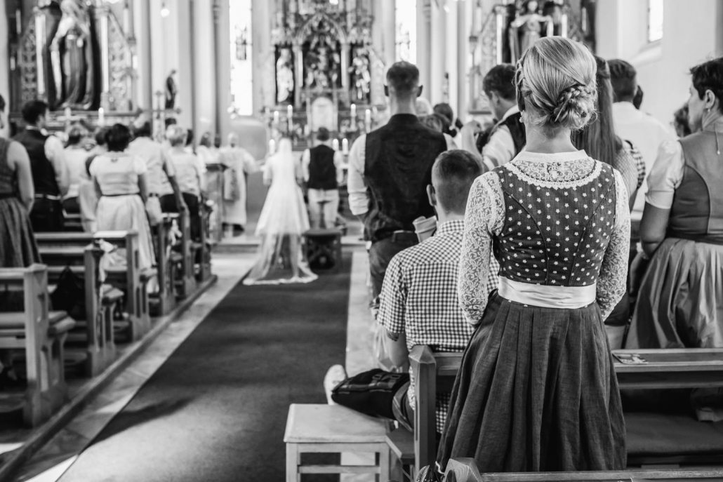 kirchliche Hochzeit in Bad Füssing, Hochzeitsgast in Tracht schaut sich die Trauung an