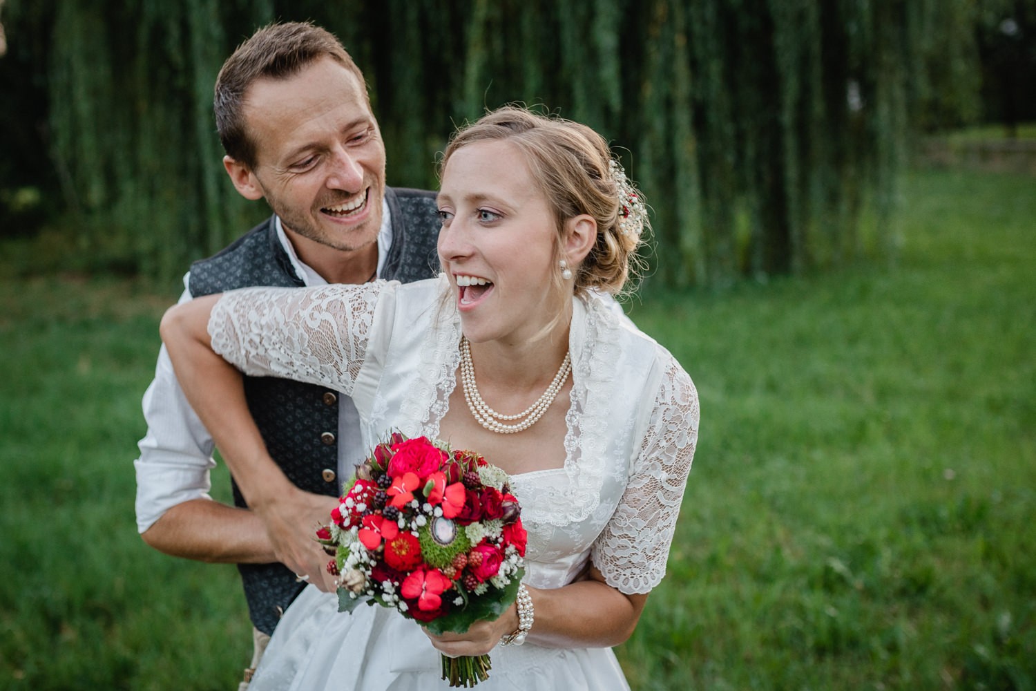 Hochzeit beim Schlosswirt Sigharting, Paarshooting, Bräutigam umfässt die Braut von hinten