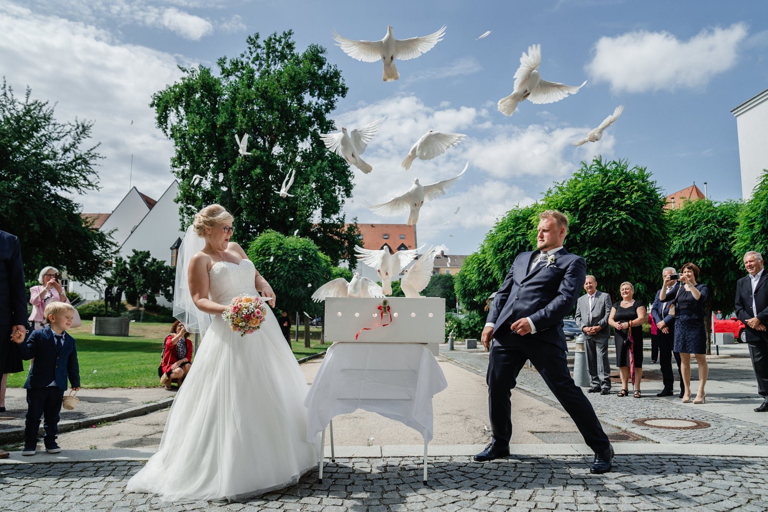 Hochzeit in Fürstenzell, Brautpaar weicht den aufsteigenden Tauben aus