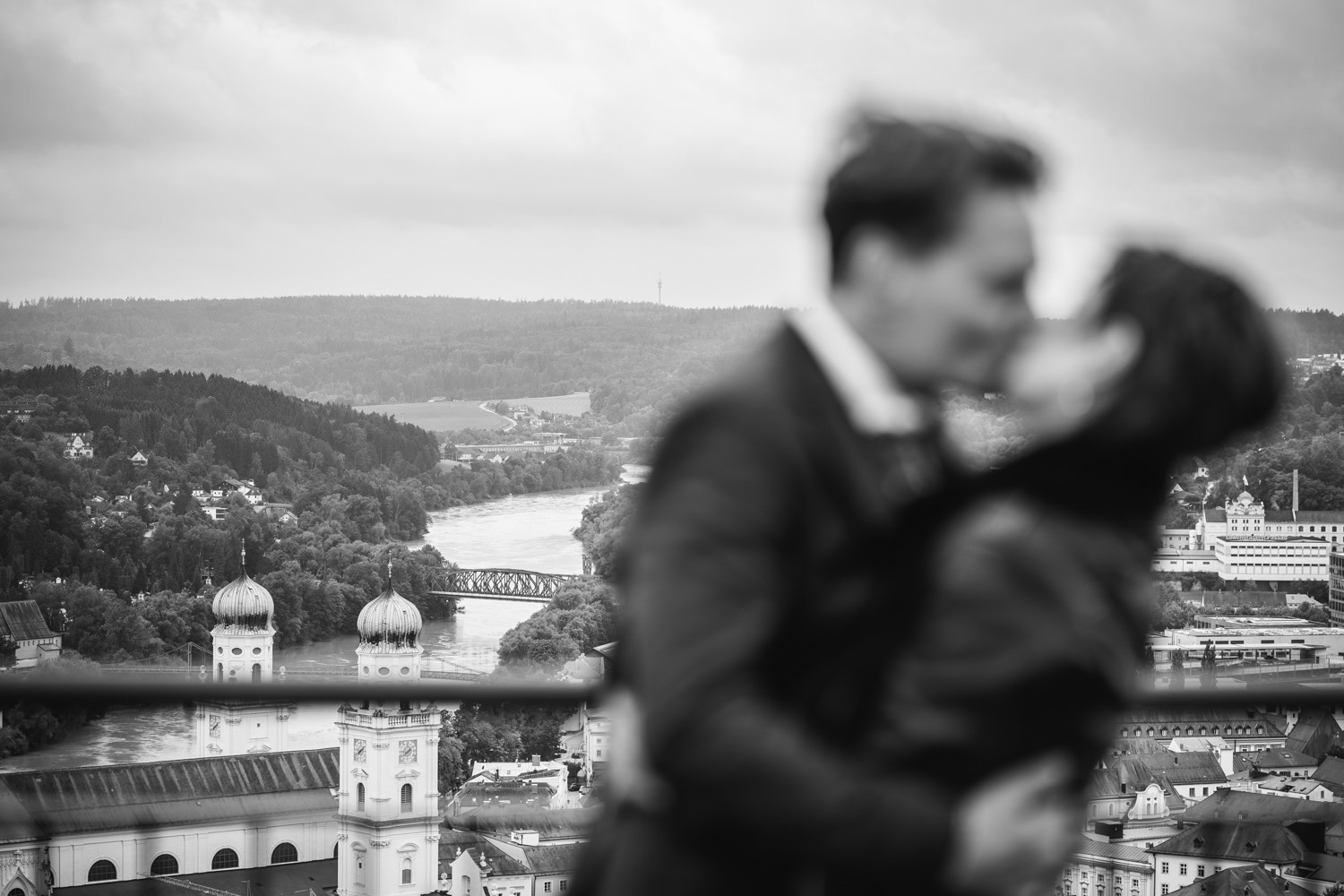Hochzeit in der Veste Oberhaus in Passau, Paarshooting, Brautpaar küsst sich vor dem Stadtpanorama