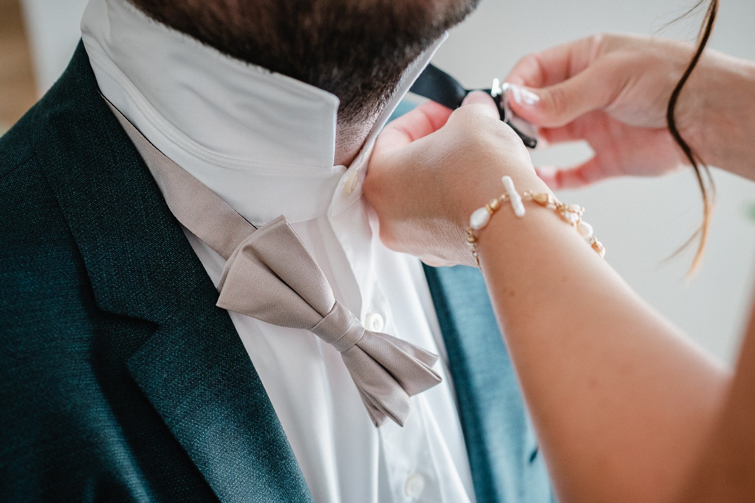 Hochzeit in Bad Birnbach, Getting Ready in Osterhofen, Braut bindet Bräutigam die Fliege um