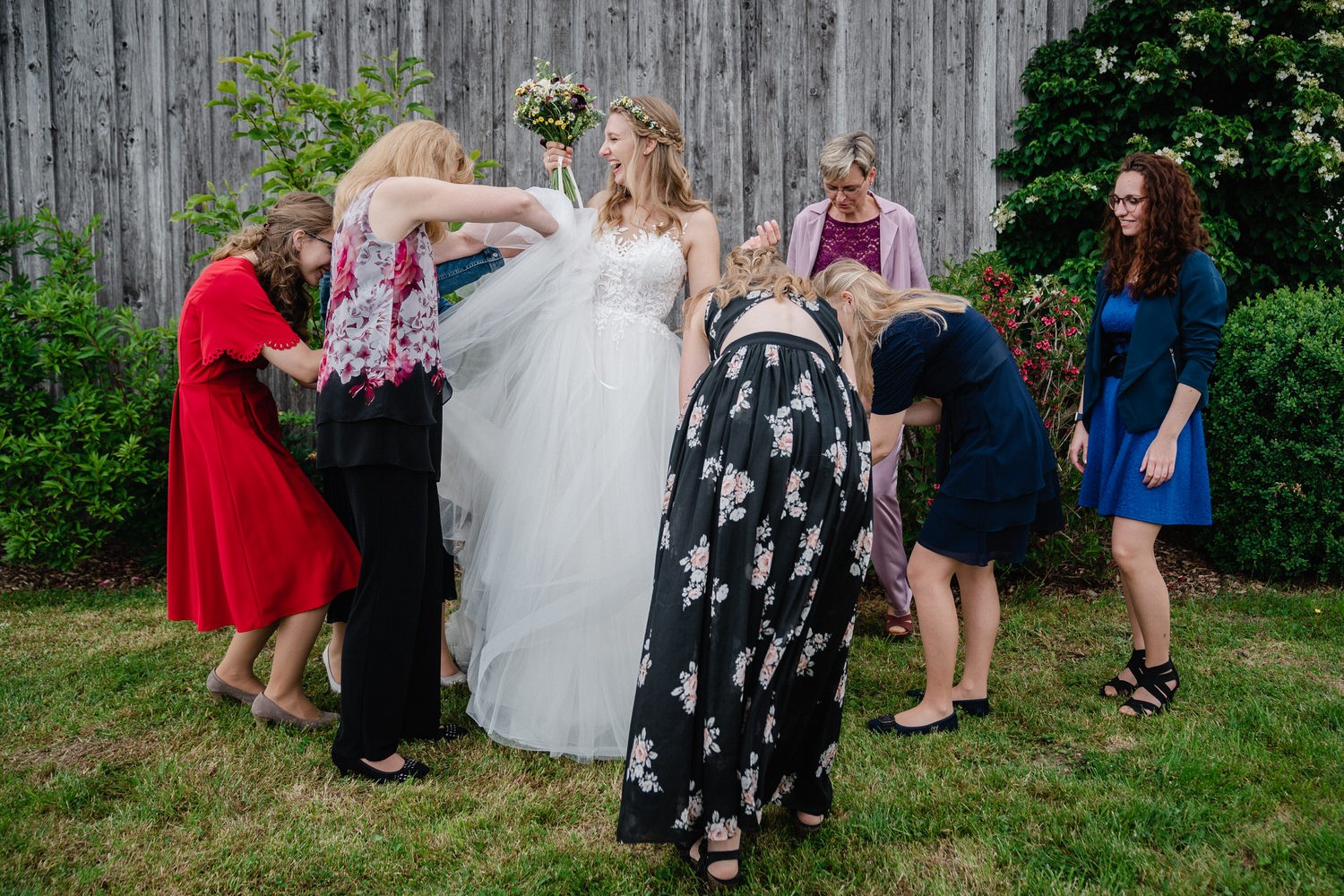 Hochzeit in Fürstenzell, die weiblichen Gäste präperieren die Braut für das Paarshooting
