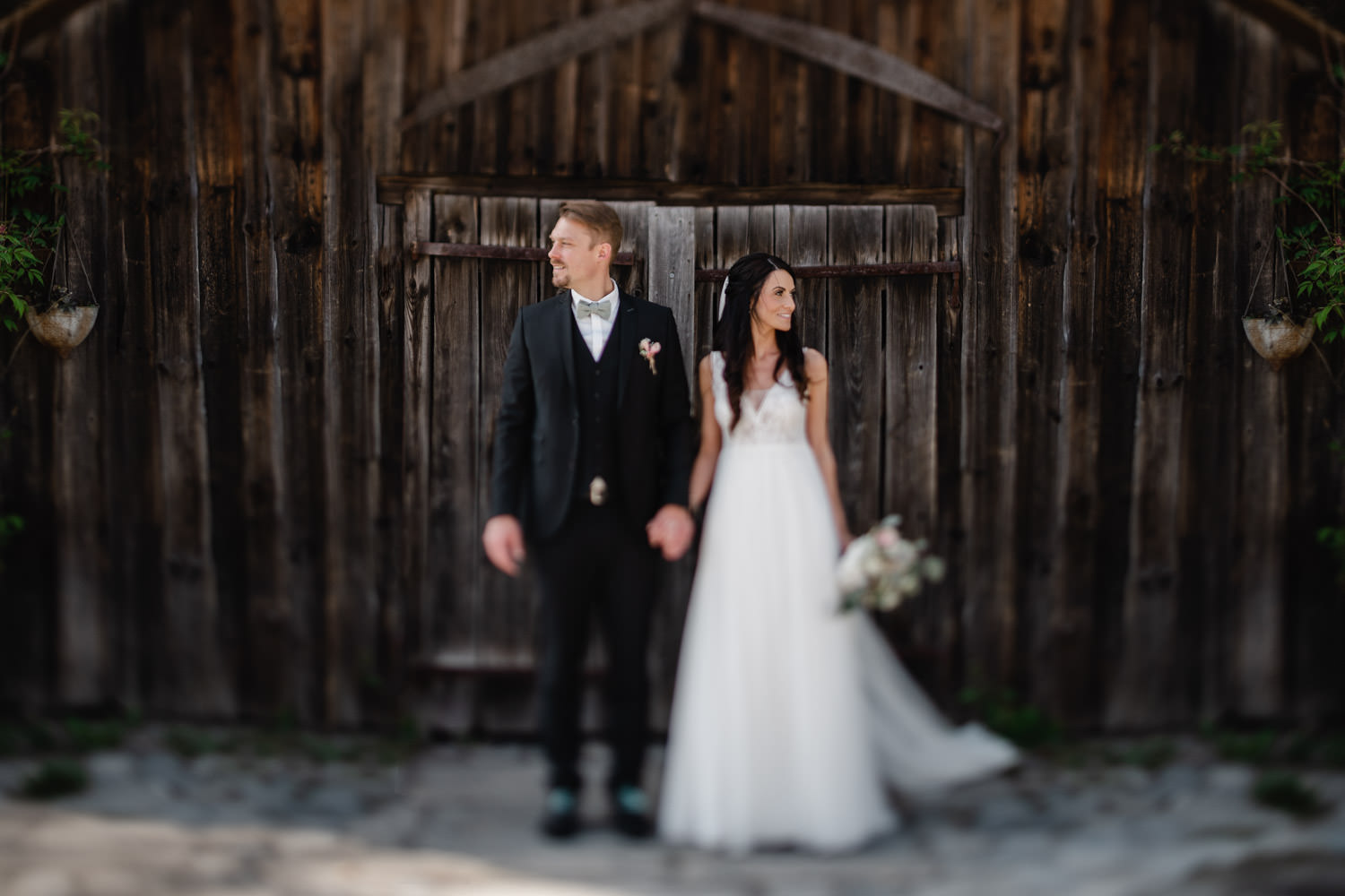 Hochzeit Gutsalm Harlachberg, Paarshooting, das Paar vor einer Scheunentür