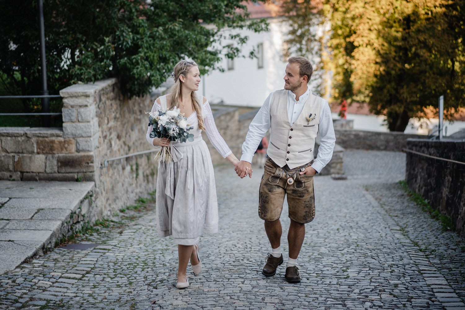 Hochzeit in der Veste Oberhaus Passau, Paarshooting, Brautpaar läuft Hand in Hand