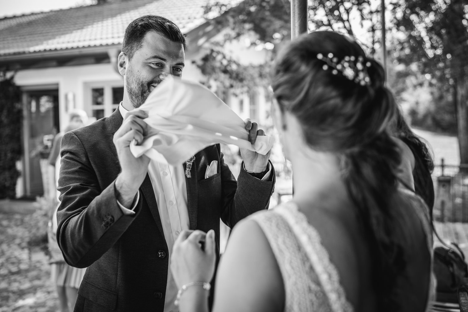 Hochzeit im Hofgut Hafnerleiten, Bad Birnbach, Bräutigam fächert der braut frische Luft zu