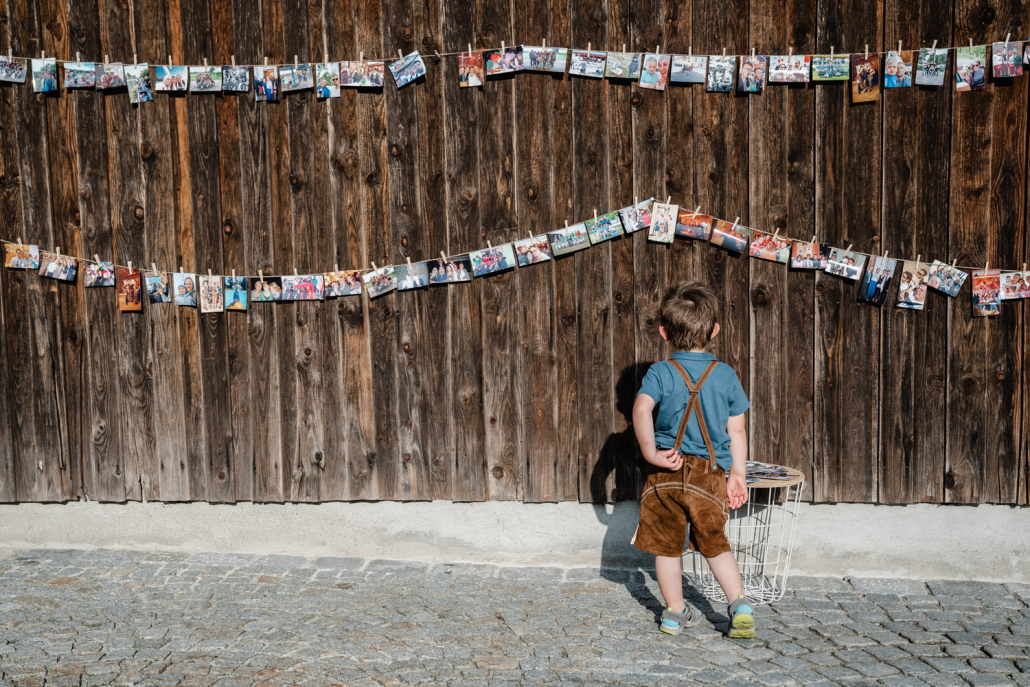 Hochzeit auf dem Rahaberghof, Oberösterreich, kleiner Junge schaut auf die Bilderwand