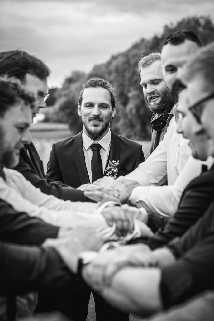Hochzeit in Fürstenzell, der bräutigam blickt auf die männlichen gäste, die ihn in die Luft werfen wollen