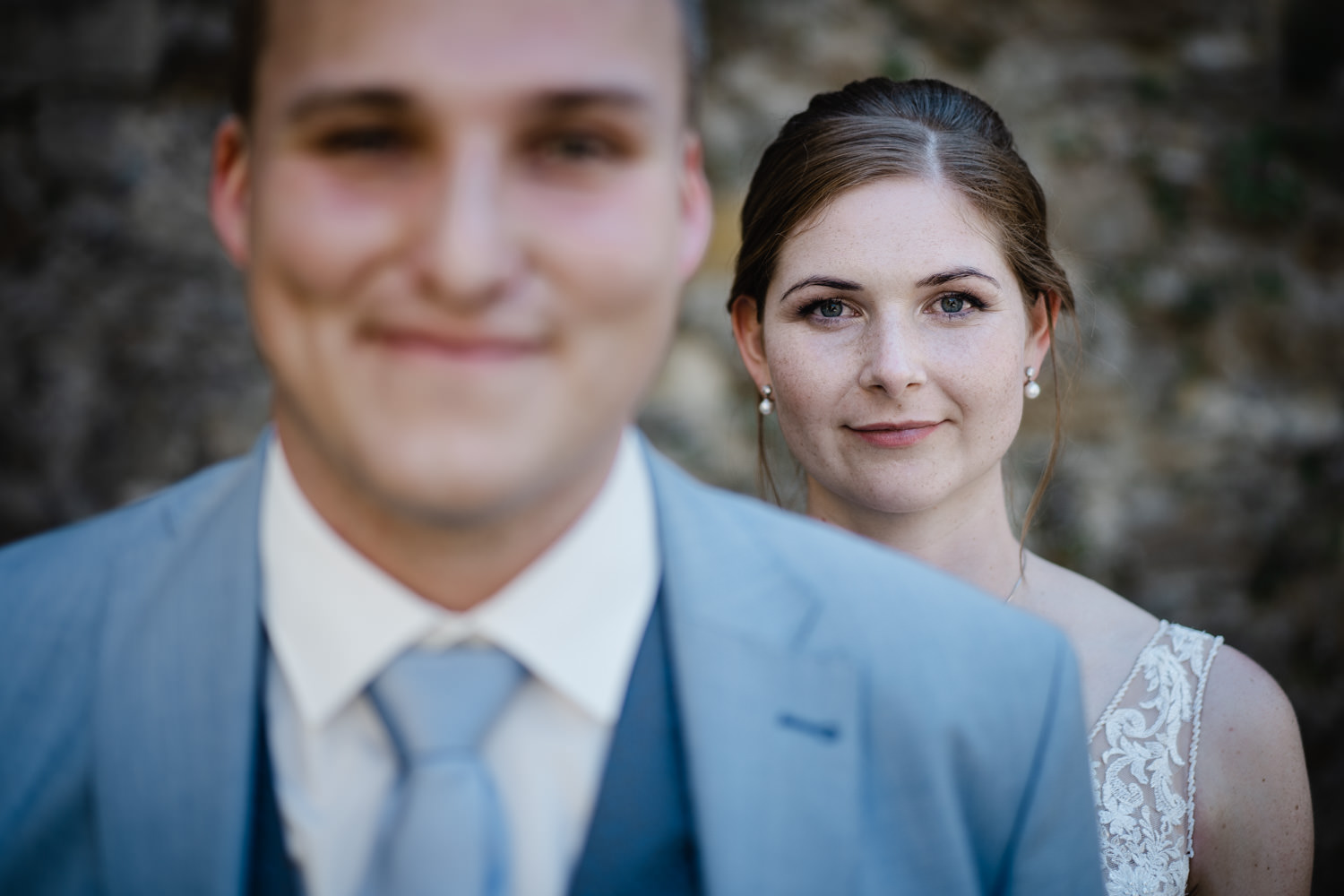 Hochzeit in Passau, Veste Oberhaus, Paarshooting, die Braut steht hinter dem Bräutigam und blickt in die Kamera