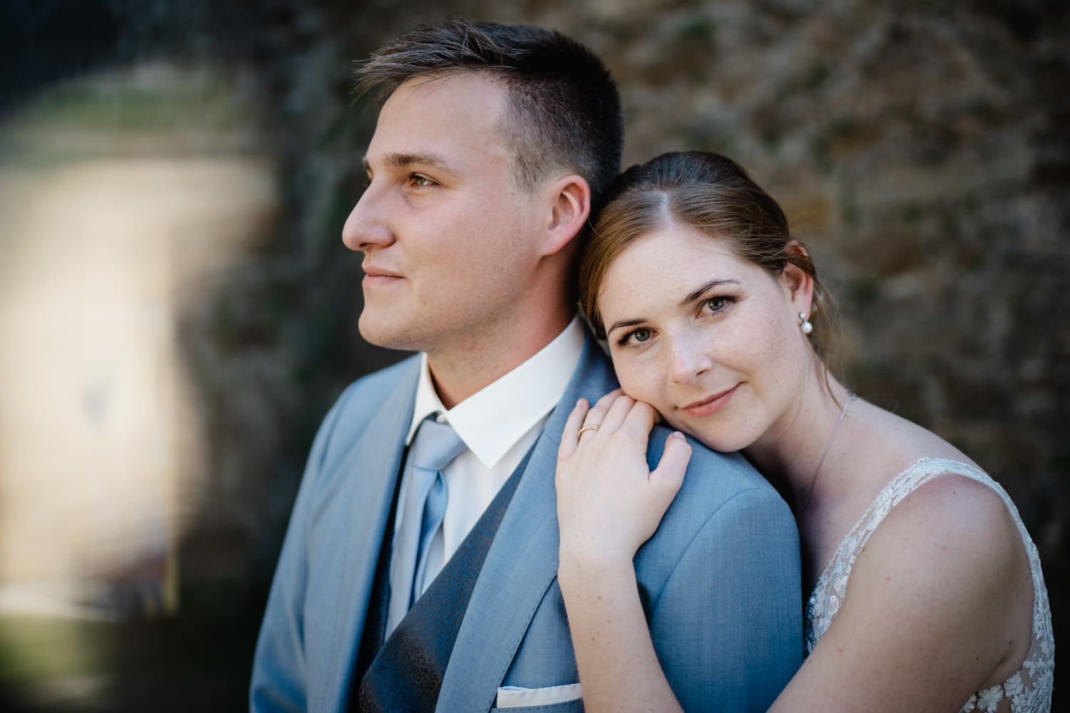 Hochzeit in Passau, Veste Oberhaus, Paarshooting, Braut schaut in die Kamera, während der Bräutigam in die Ferne blickt