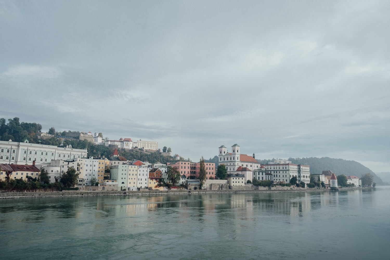 Sicht auf die Passauer Altstadt mit dem Inn im Vordergrund und der Veste Oberhaus im Hintergrund