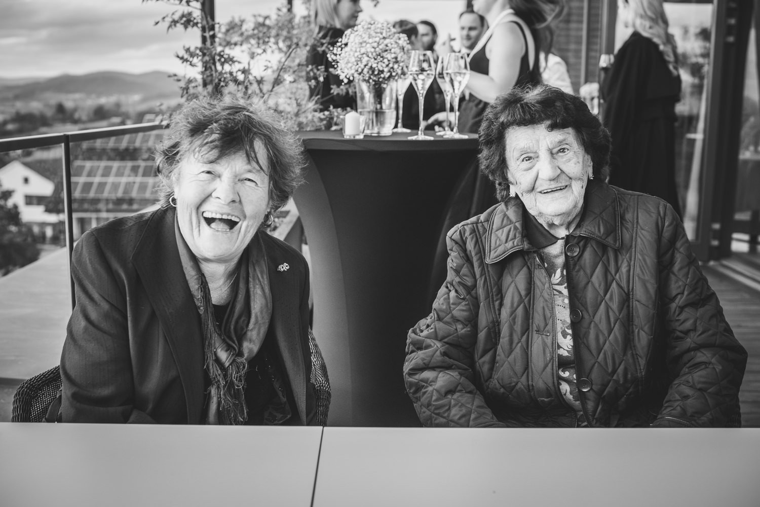 Die Omas des Brautpaares sitzen beieinander und lachen in die Kamera